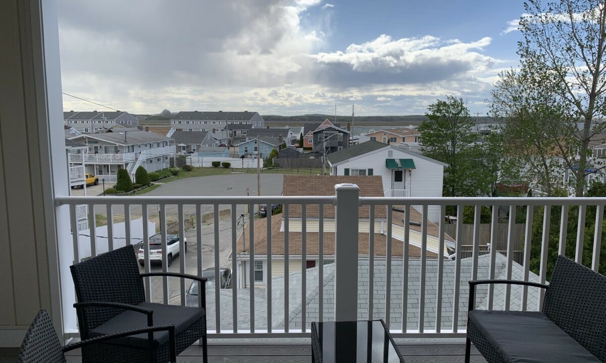 a balcony with two chairs and a table on it.