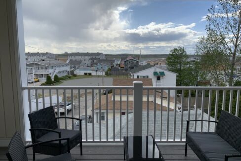 a balcony with two chairs and a table on it.