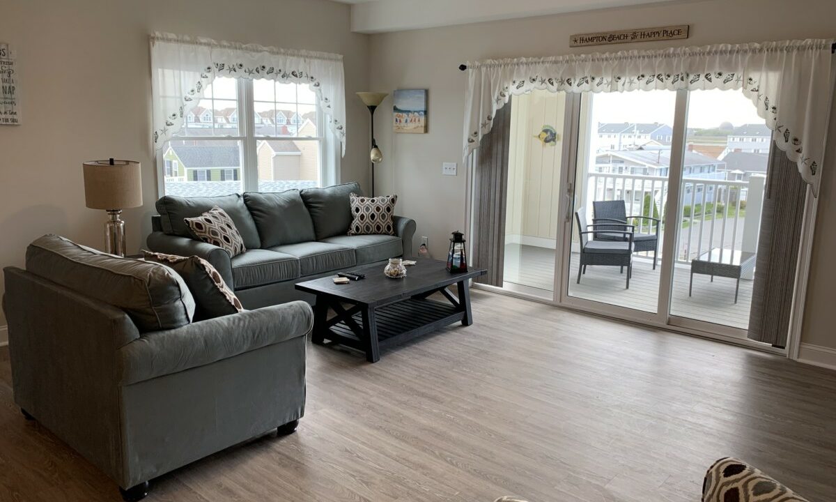 a living room filled with furniture and a sliding glass door.