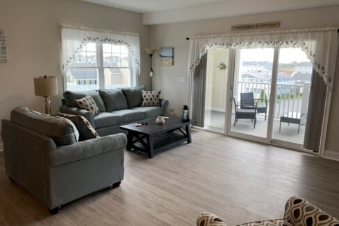 a living room filled with furniture and a sliding glass door.