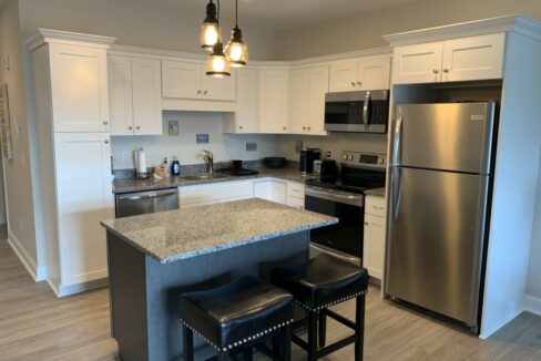 a kitchen with an island and two stools.
