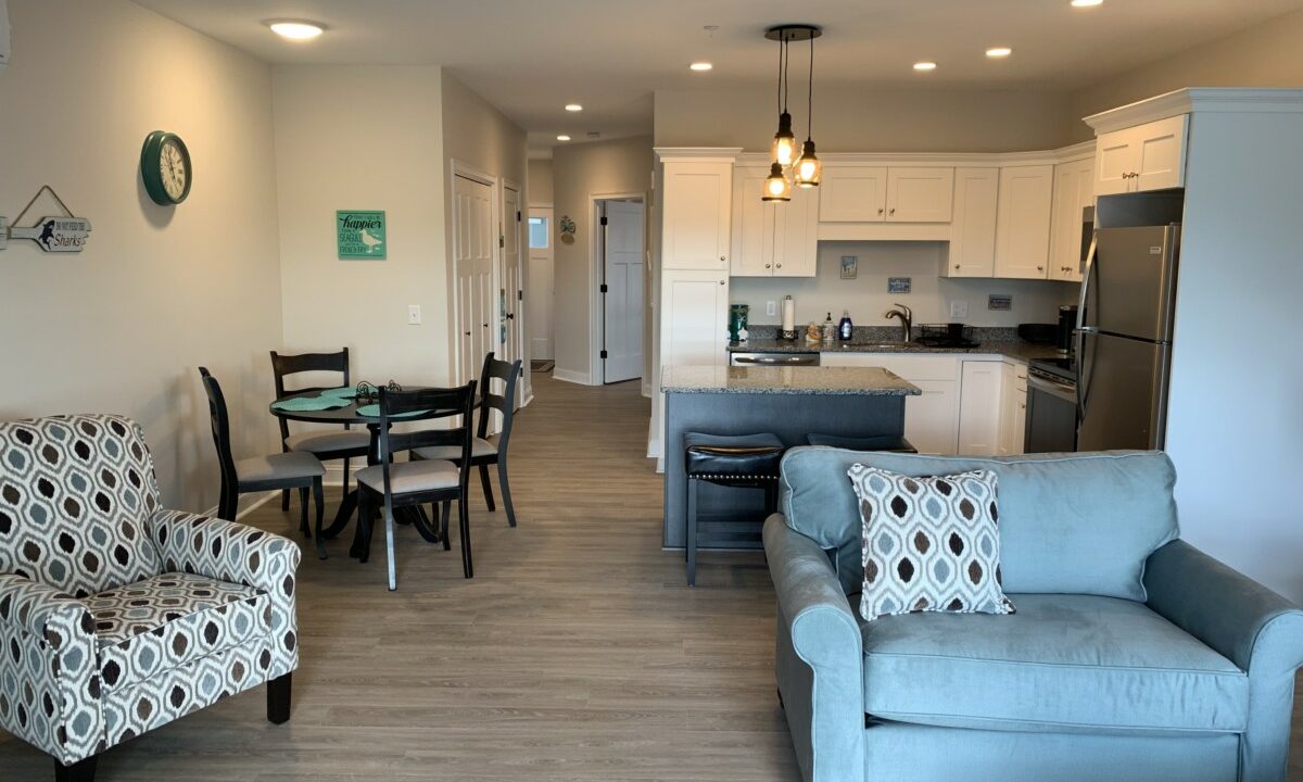 a living room filled with furniture and a kitchen.
