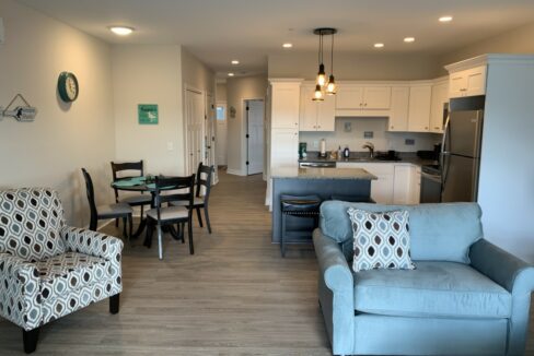 a living room filled with furniture and a kitchen.