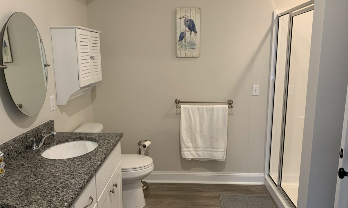 a bathroom with two sinks, a toilet, and a shower.