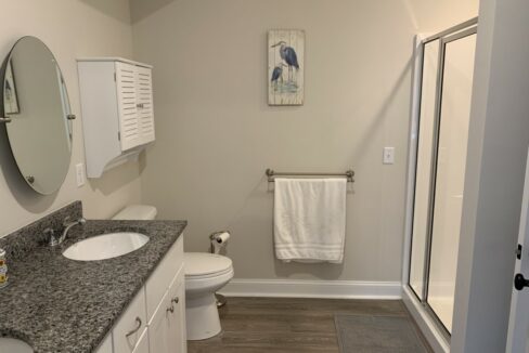 a bathroom with two sinks, a toilet, and a shower.