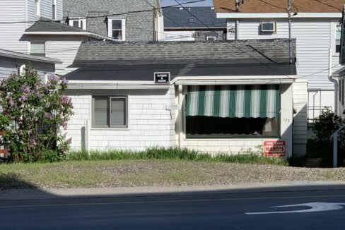 a white house with a green and white striped awning.