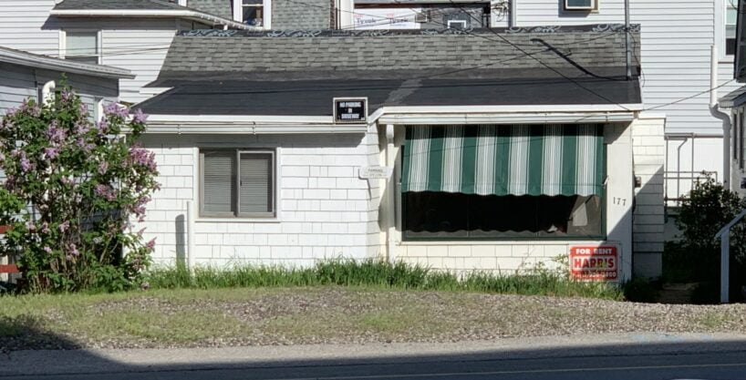 a white house with a green and white striped awning.