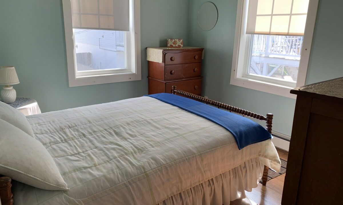 a bedroom with a bed and two windows.
