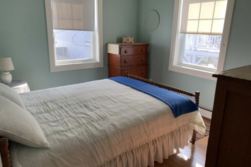 a bedroom with a bed and two windows.