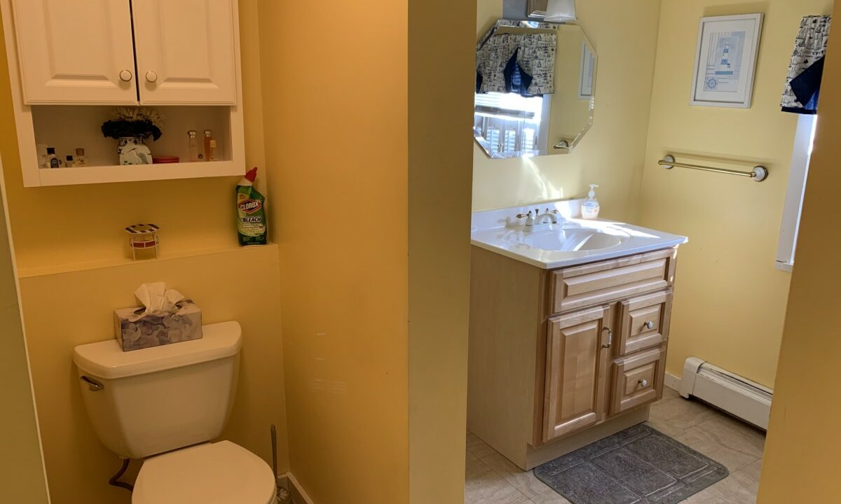 a white toilet sitting next to a bathroom sink.