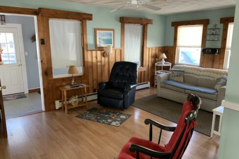 a living room filled with furniture and a ceiling fan.