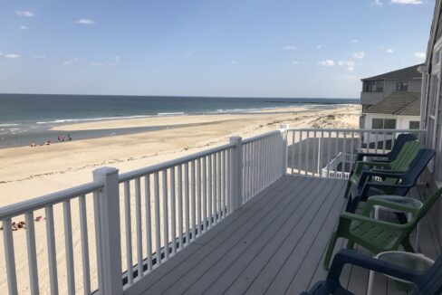 a couple of lawn chairs sitting on top of a wooden deck.