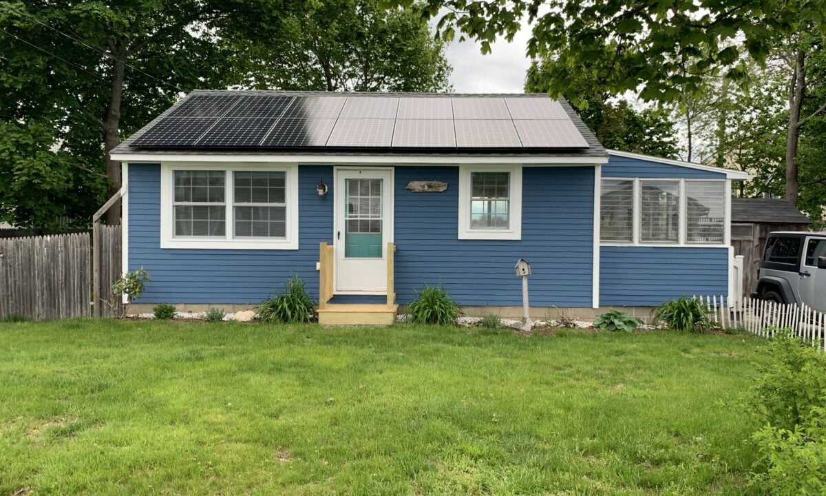 a small blue house with a metal roof.