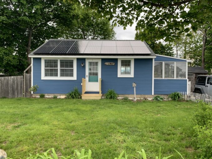 a small blue house with a metal roof.