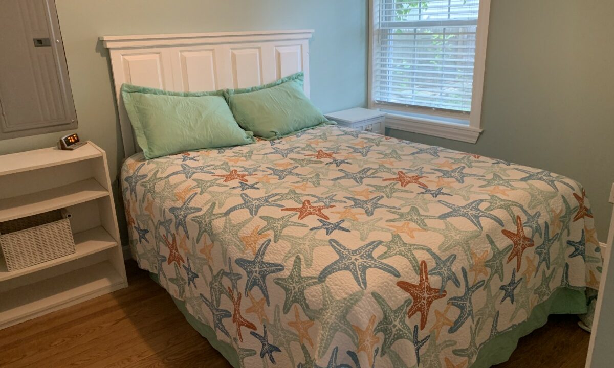 a bed with a starfish quilt on top of it.