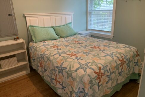 a bed with a starfish quilt on top of it.
