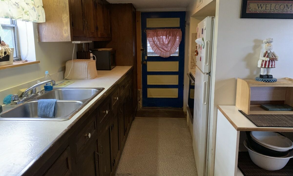 a kitchen with a sink, stove, refrigerator and microwave.