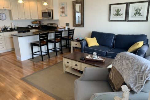 a living room filled with furniture and a kitchen.