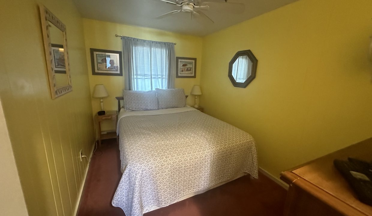 a bedroom with a bed and a ceiling fan.