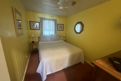 a bedroom with a bed and a ceiling fan.