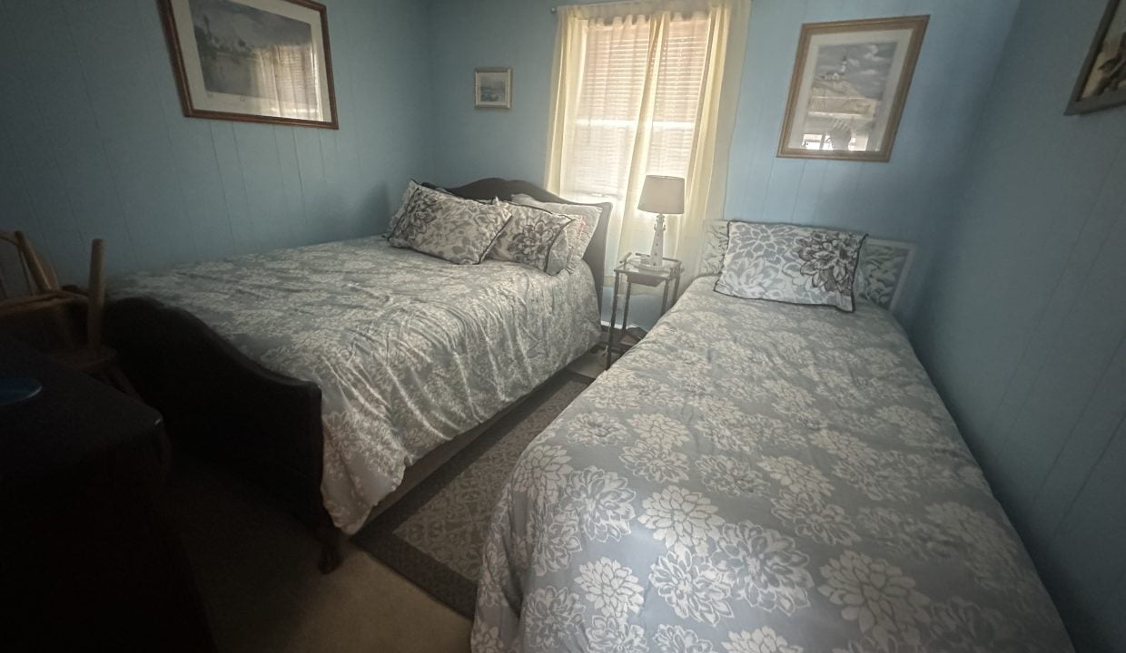 a couple of beds sitting in a bedroom next to a window.