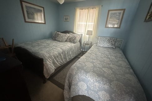 a couple of beds sitting in a bedroom next to a window.