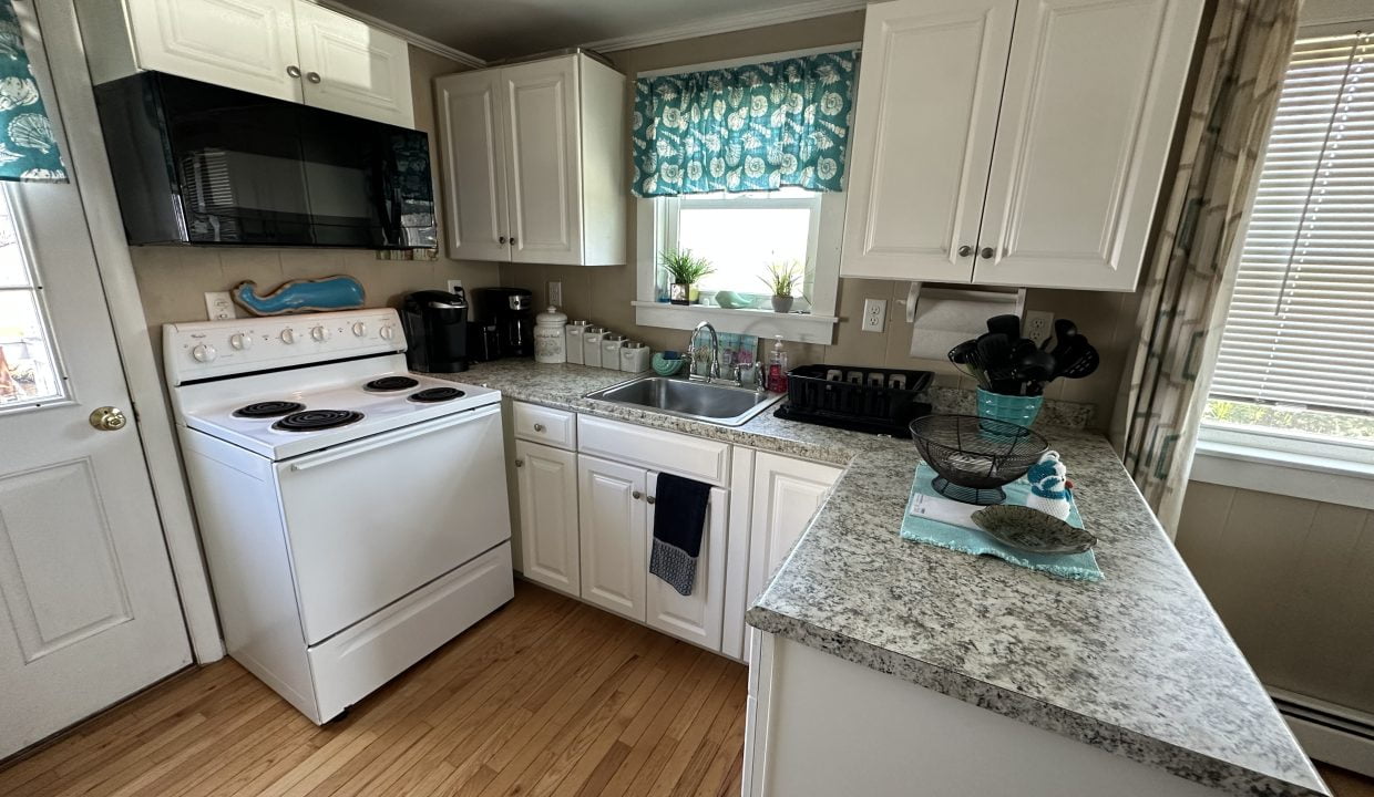 a kitchen with white cabinets and granite counter tops.