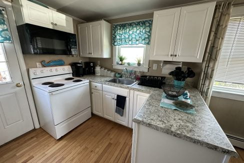 a kitchen with white cabinets and granite counter tops.