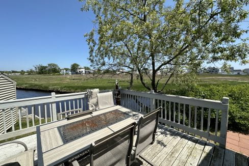 a wooden deck with a table and chairs on it.