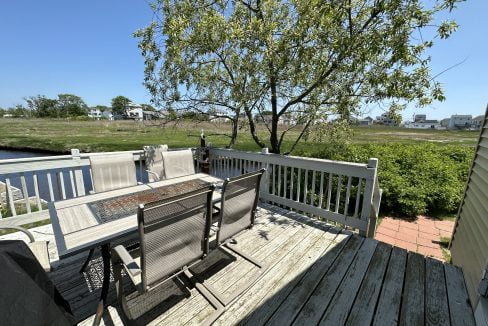 a wooden deck with two chairs and a table.