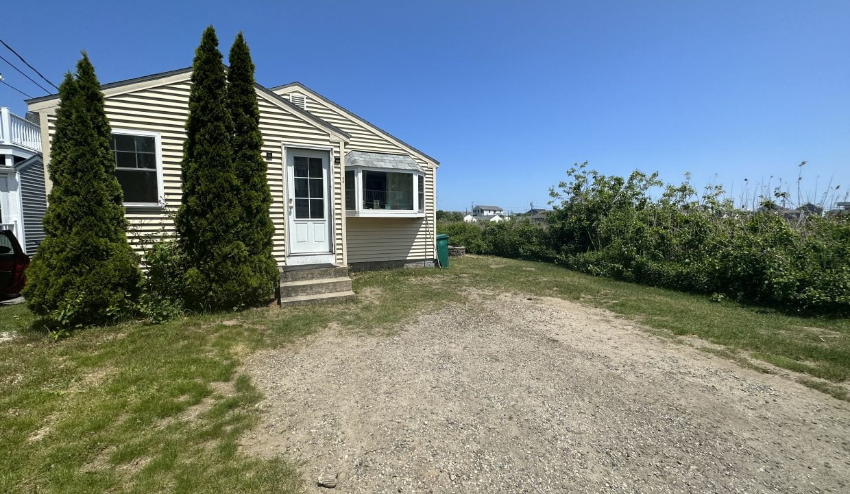 a dirt road in front of a house.