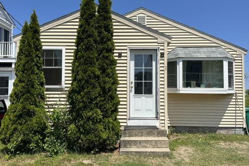 a house with three trees in front of it.