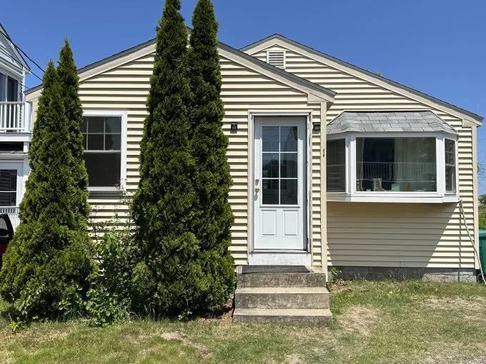 a house with three trees in front of it.