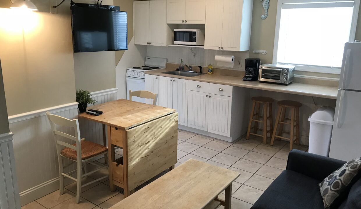 a kitchen and living room with a table and chairs.