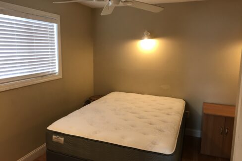 a bedroom with a bed and a ceiling fan.