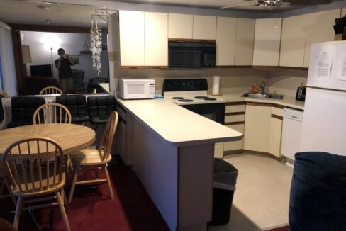 a kitchen with a refrigerator, stove, microwave and table.