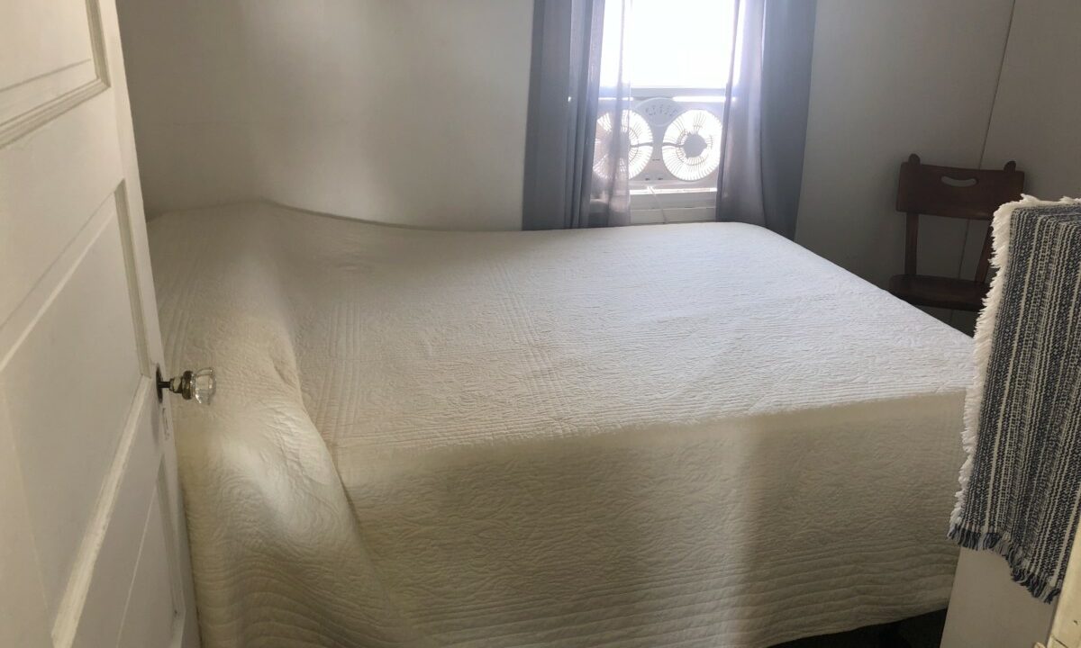 a bed sitting in a bedroom next to a window.