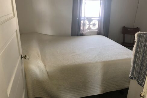 a bed sitting in a bedroom next to a window.