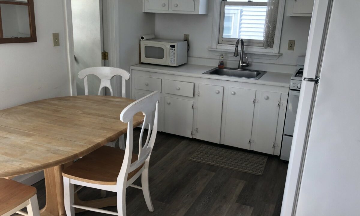 a kitchen with a wooden table and white cabinets.