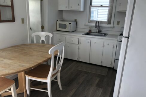 a kitchen with a wooden table and white cabinets.