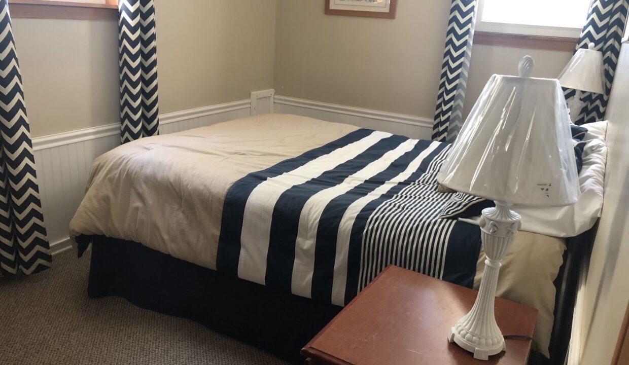 a bed room with a neatly made bed and a night stand.