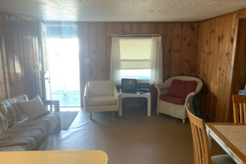 a living room filled with furniture and wooden walls.