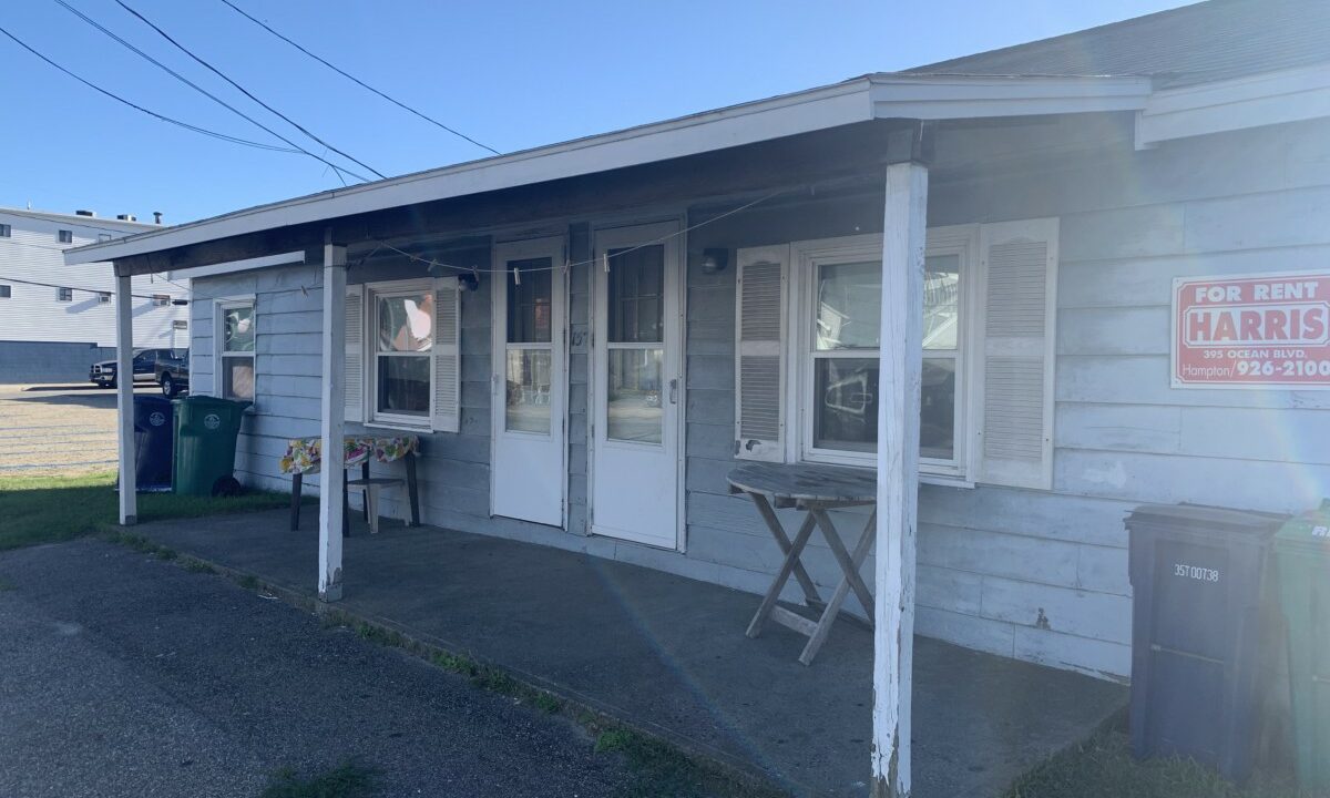 a small white building with a sign on the front of it.