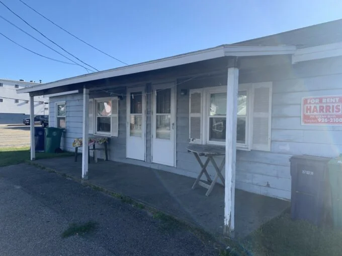 a small white building with a sign on the front of it.
