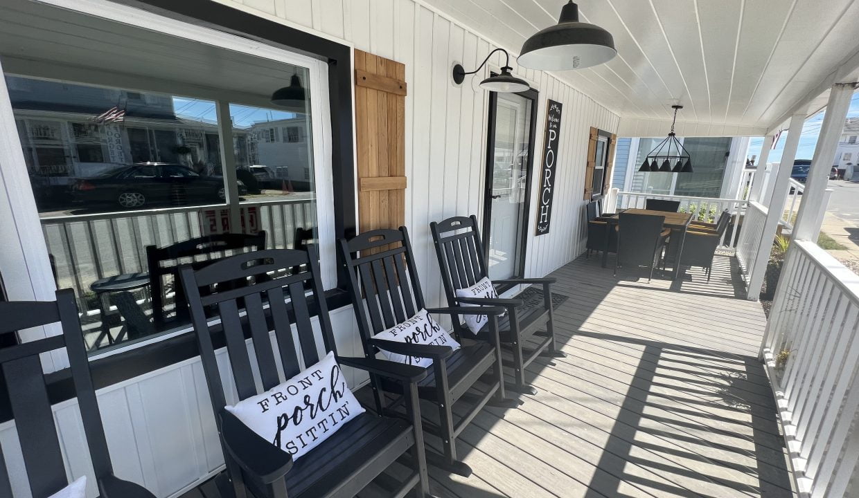 a porch with chairs and a lamp on it.