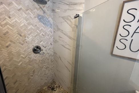 a walk in shower sitting next to a white toilet.