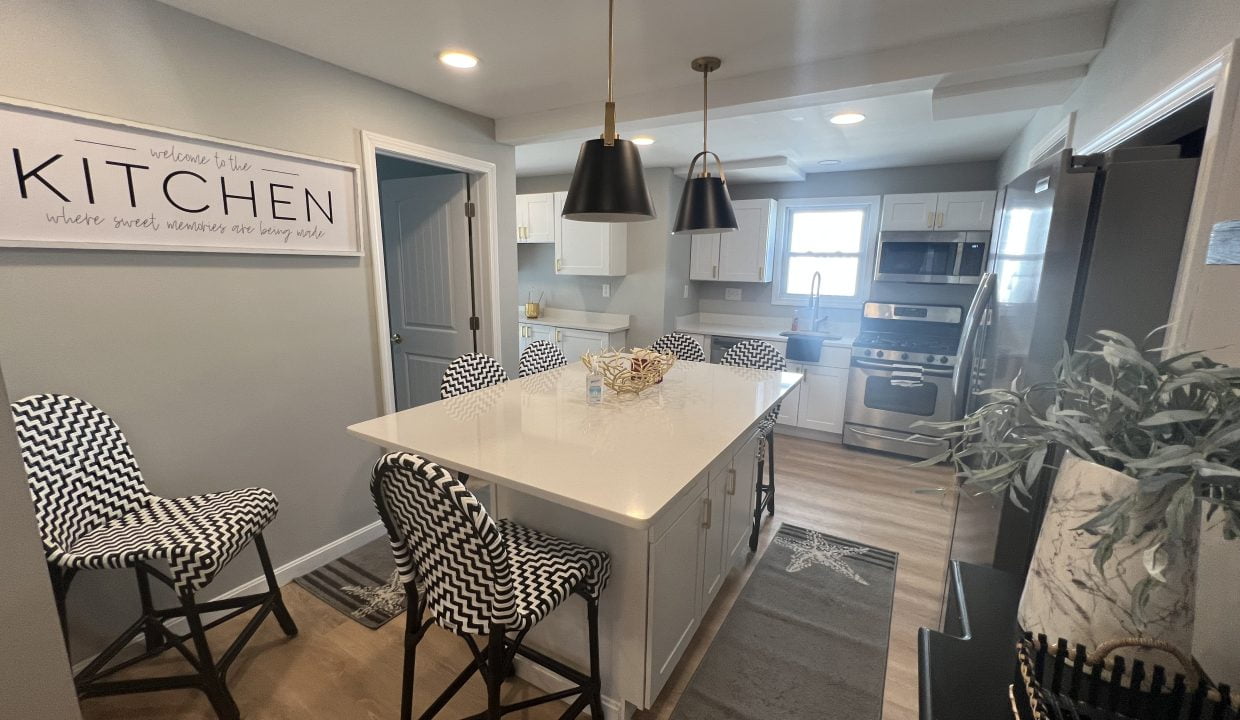 a kitchen with a center island and chairs.
