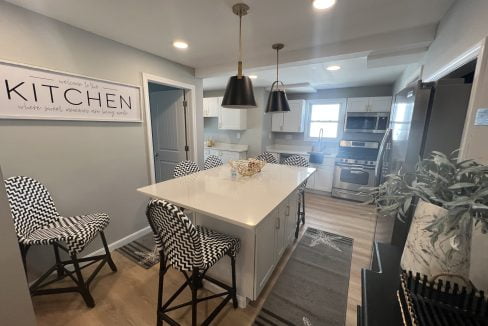 a kitchen with a center island and chairs.