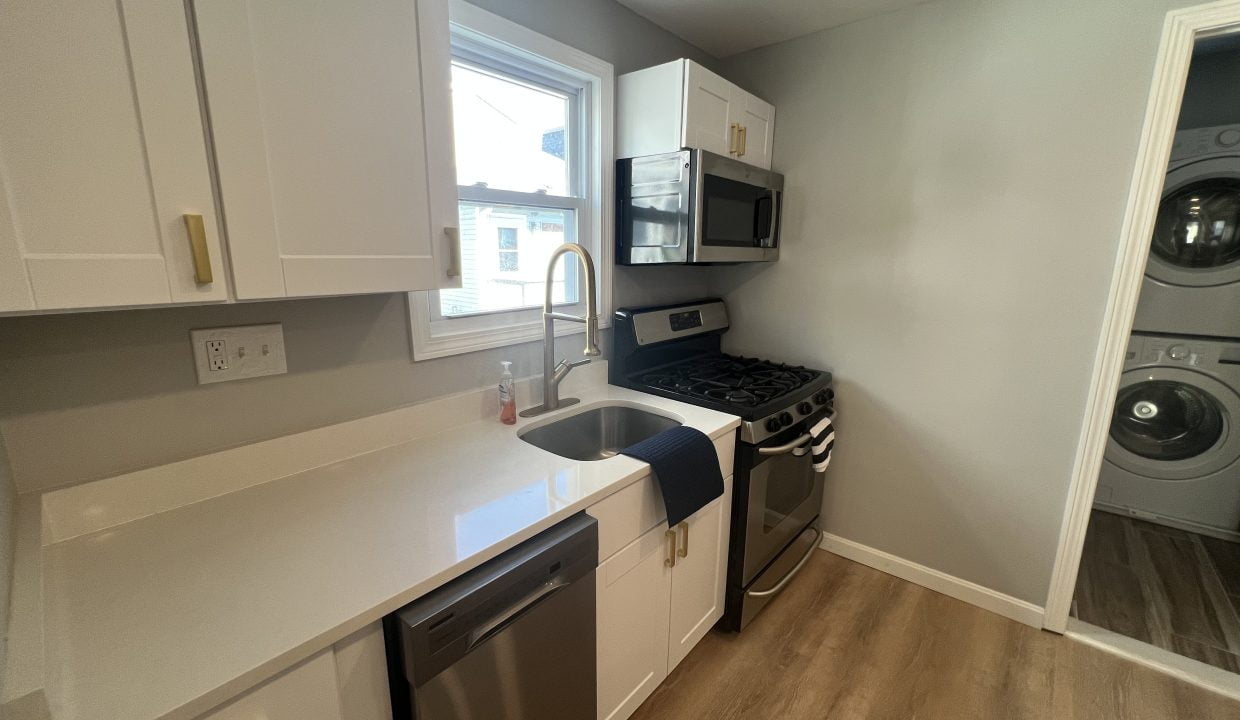a kitchen with a sink, stove, dishwasher and washer.