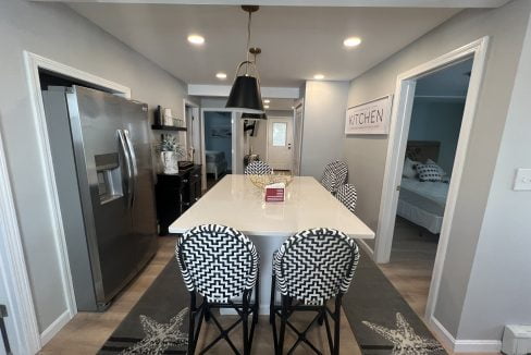 a kitchen with a refrigerator and a table with four chairs.